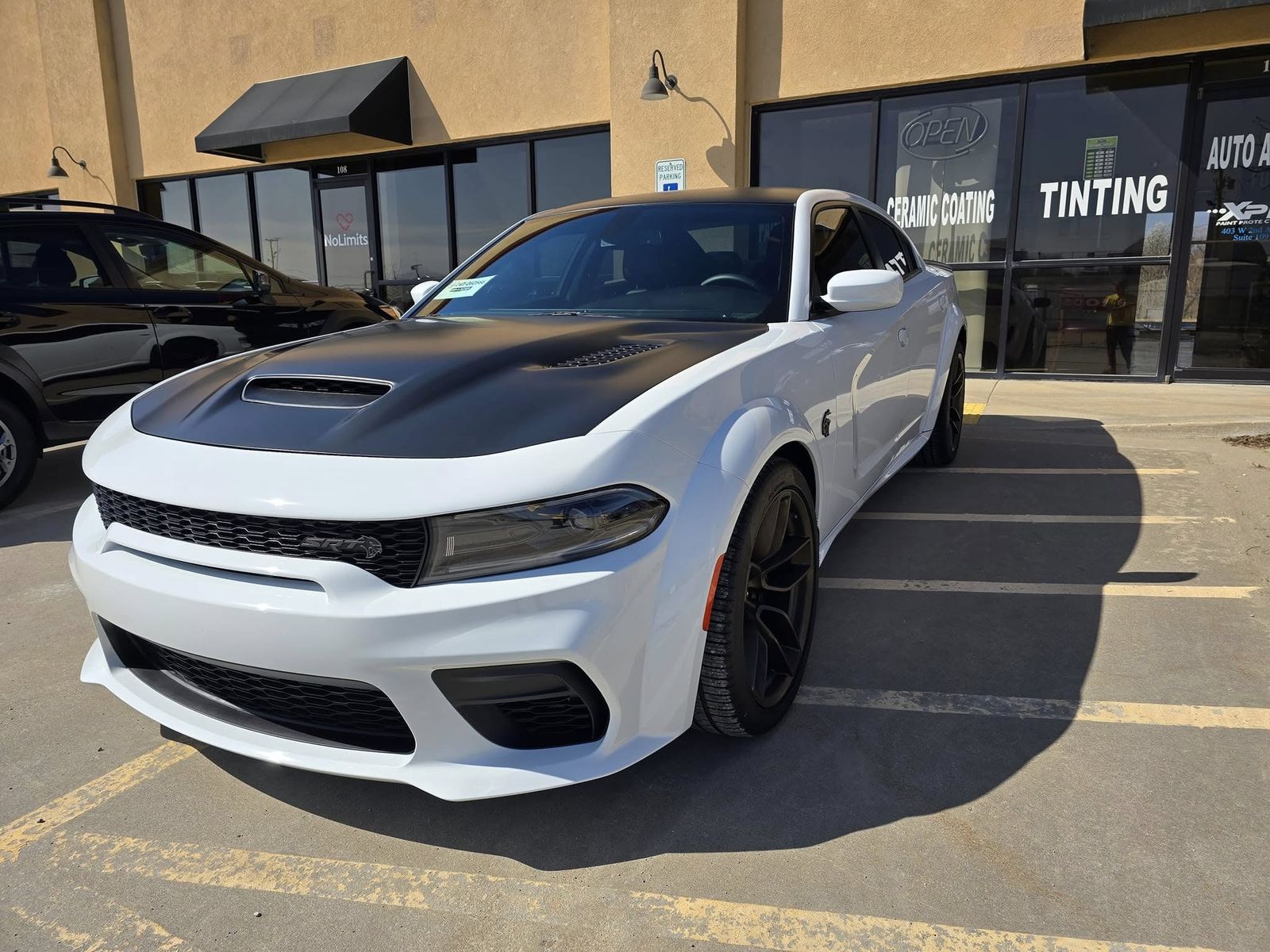 White Dodge Charger Hellcat Widebody with dark window tint outside Auto Armor Owasso