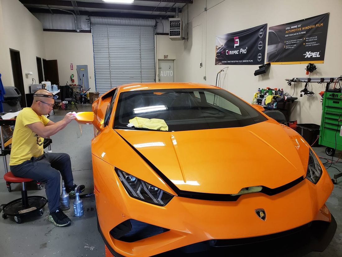 Vang Ge Lee installing paint protection film on an orange Lamborghini Huracán EVO
