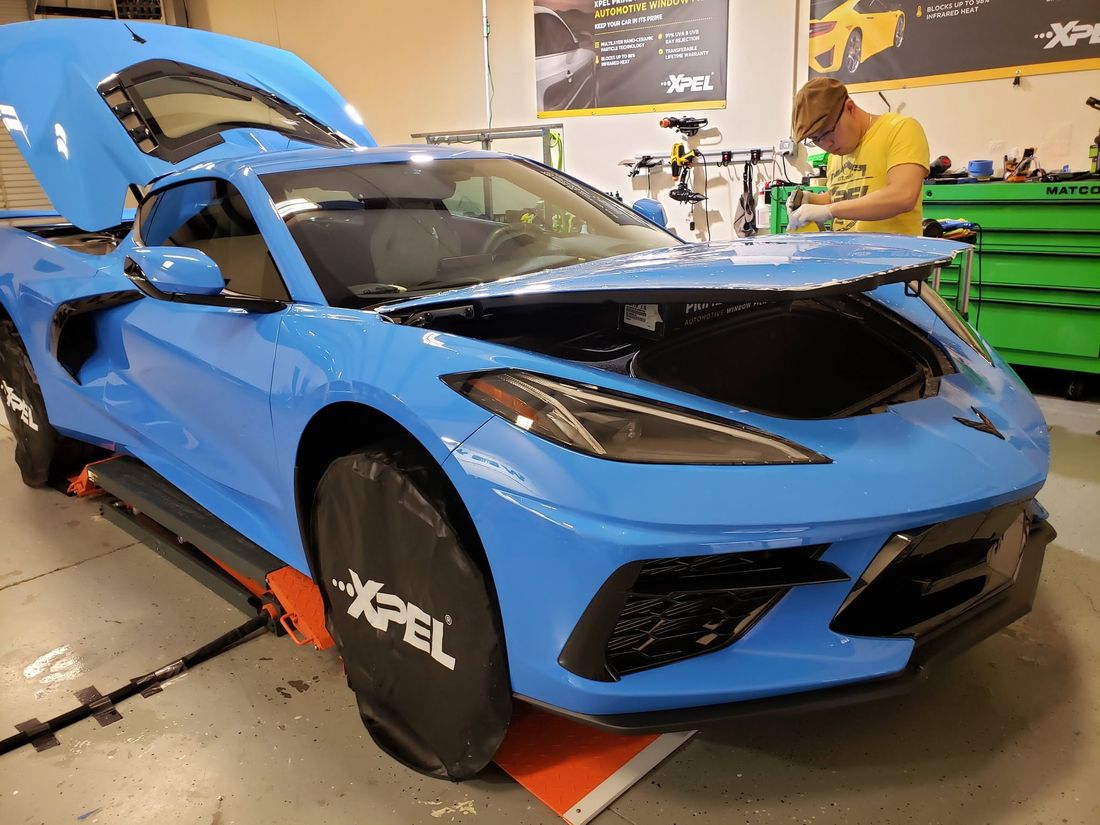 Paint protection film going onto a Rapid Blue C8 Corvette in the bay