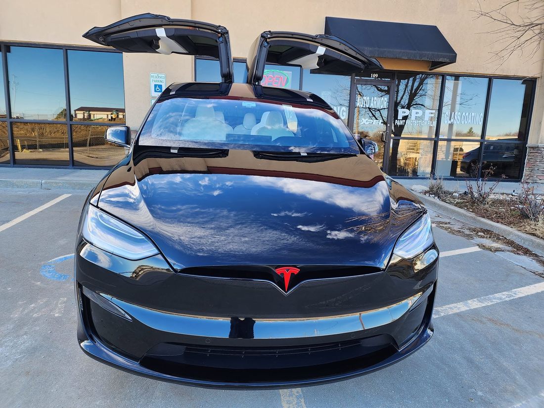Black Tesla Model X with its falcon-wing doors up outside Auto Armor Owasso